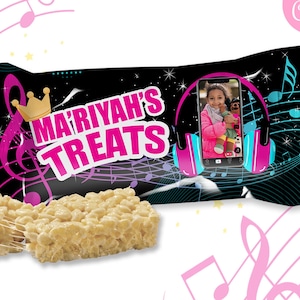 May include: A black and pink treat bag with a music note design and the text "MARIYAH'S TREATS". A photo of a girl is in the center of the bag. The bag is next to two white rice crispy treats.