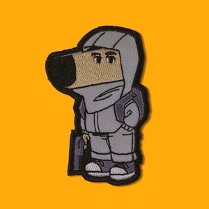 Op de afbeelding: Een cartoonfiguur draagt ​​een paarse capuchontrui en draagt ​​een zwarte tas. Het personage heeft een bruine snuit en draagt ​​een grijze broek.