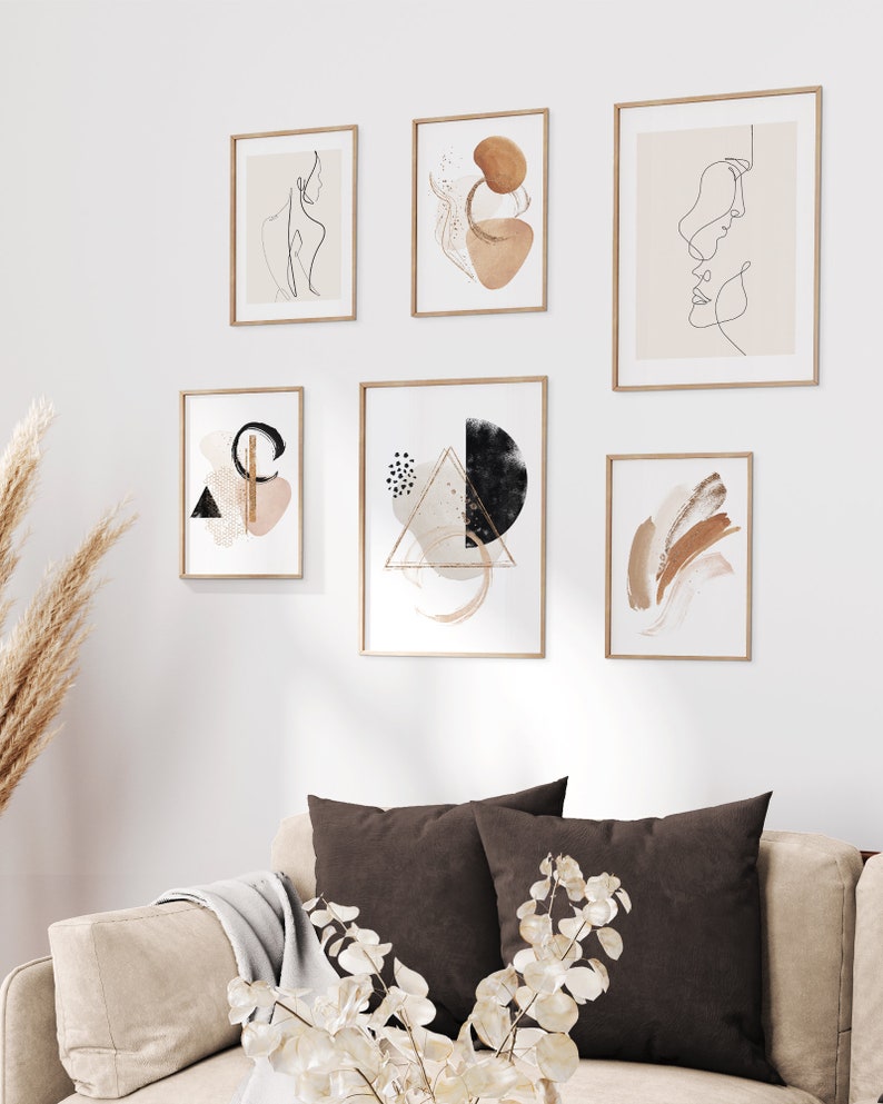May include: A set of six minimalist art prints in wooden frames, featuring abstract shapes, line drawings, and geometric patterns in shades of brown, black, and white.