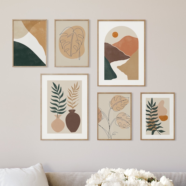 May include: Set of six minimalist art prints featuring abstract line drawings of plants and landscapes in shades of brown, green, and beige. The prints are framed in a light wood frame.