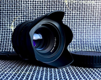 May include: A black camera lens with a lens hood. The lens is labeled "HELIOS-44M".