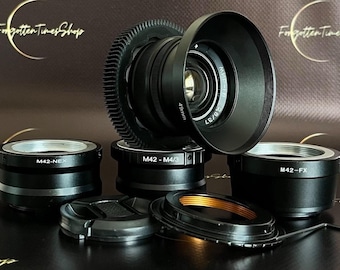 May include: A set of six black camera lens adapters, including a 49mm lens with a lens hood. The adapters are labeled with the text "M42-NEX", "M42-M4/3", and "M42-FX".