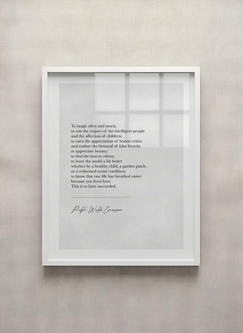 May include: A framed print with a white border, featuring a quote by Ralph Waldo Emerson in a minimalist style. The text is in a simple, elegant font on a light gray background. The quote is about the meaning of success.