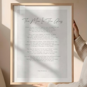 May include: Framed print featuring the poem "The Man In The Glass" by Dale Wimbrow. The text is in a black, elegant font on a white background, set within a light wood frame. The poem's title is in a cursive font.