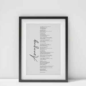 May include: A framed print with a black frame. The print features the word "Amazing" in cursive on the left side and lyrics in a smaller font on a light gray background. The lyrics are attributed to George Michael.