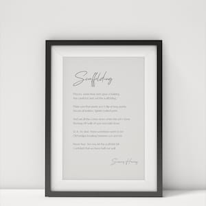 Könnte beinhalten: Ein gerahmter Druck in einem schwarzen Rahmen mit dem Wort "Scaffolding" in Schreibschrift. Der Druck enthält ein Gedicht über Bauen und Beziehungen, mit der Unterschrift des Autors unten. Der Hintergrund ist hellgrau.