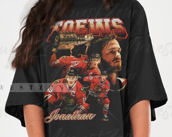 May include: Black oversized t-shirt with a vintage-style graphic of a hockey player holding a trophy. The graphic includes the text "TOEWS" and "Jonathan".