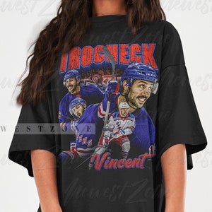May include: Black oversized t-shirt with a vintage graphic print of hockey players wearing blue and red jerseys. The text "Vincent" and "BROCHECK" are printed on the shirt.