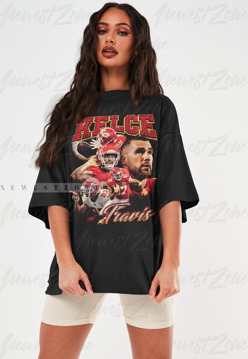 May include: Black oversized t-shirt with a vintage-style graphic of Travis Kelce, a football player for the Kansas City Chiefs. The graphic features Kelce's name and number, "87", in a red and yellow font. The shirt is a popular choice for fans of the Kansas City Chiefs.