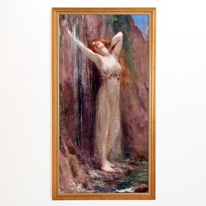 以下が含まれることがあります： 滝の下に立つ長い赤毛の女性を描いた額入りの絵画。彼女は透き通った明るい色のガウンを着ており、腕を上げています。このアートワークは、岩と水の背景に、金色のフレームで設定されています。