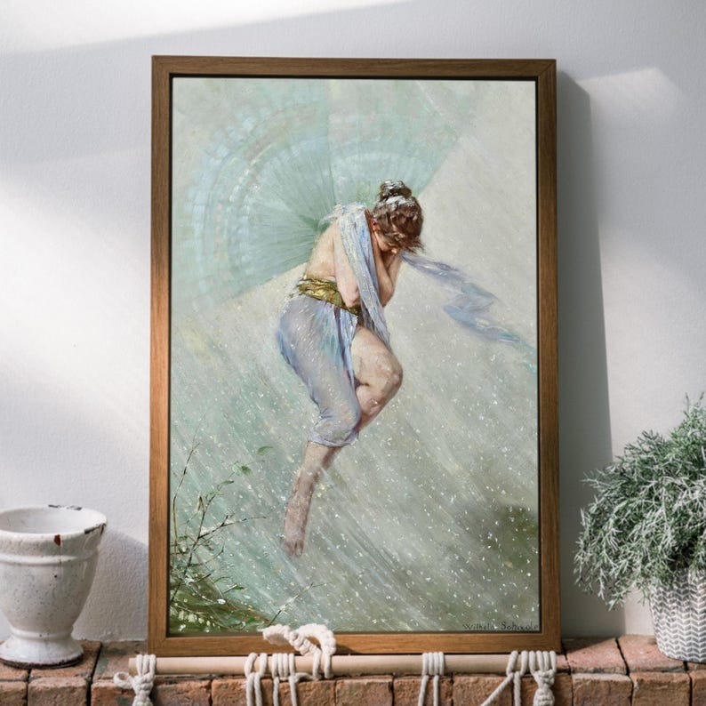 May include: A framed print of a classical painting depicting a woman in flowing blue fabric, with a light blue fan-like structure behind her. The artwork is set against a light background, framed in a brown wooden frame.