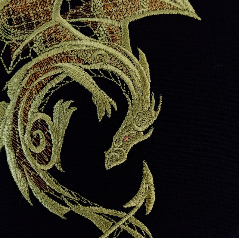 Puede incluir: Un dise&ntilde;o de drag&oacute;n bordado en oro y verde sobre un fondo de tela negro.