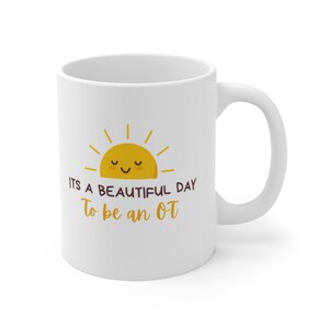 Puede incluir: Taza de cerámica blanca con un gráfico de sol amarillo y el texto "Es un día hermoso para ser un OT".