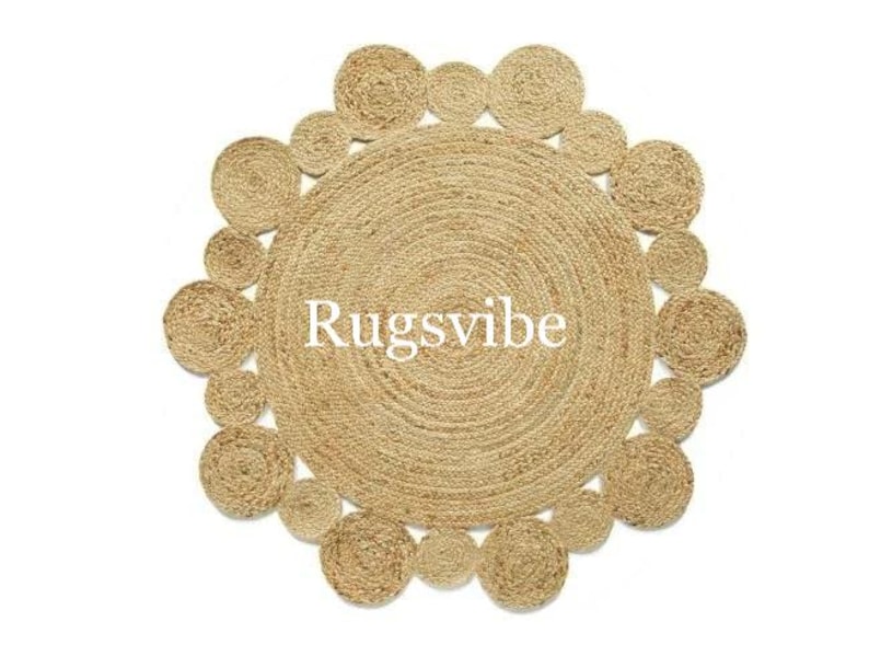 May include: A round, natural fibre rug with a woven design. The rug has a circular pattern of smaller circles around the outer edge.