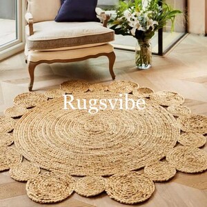 May include: A round jute rug with a circular pattern of woven circles around the edge. The rug is a natural beige colour and has a rustic, handmade look.