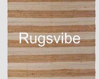 May include: A natural fiber rug with horizontal stripes in beige and brown. The rug has the text "Rugsvibe" printed in white in the center.