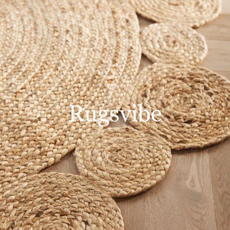 May include: A natural fibre rug with a circular design featuring a series of concentric circles in a light brown colour. The rug has a textured, woven appearance and is made of jute.