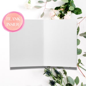 May include: A blank white card with a pink watercolor circle that says "BLANK INSIDE" on a white background with white flowers and green leaves.