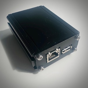 以下が含まれることがあります： 側面に銀色のイーサネットポートとUSBポートが付いた黒い長方形のデバイス