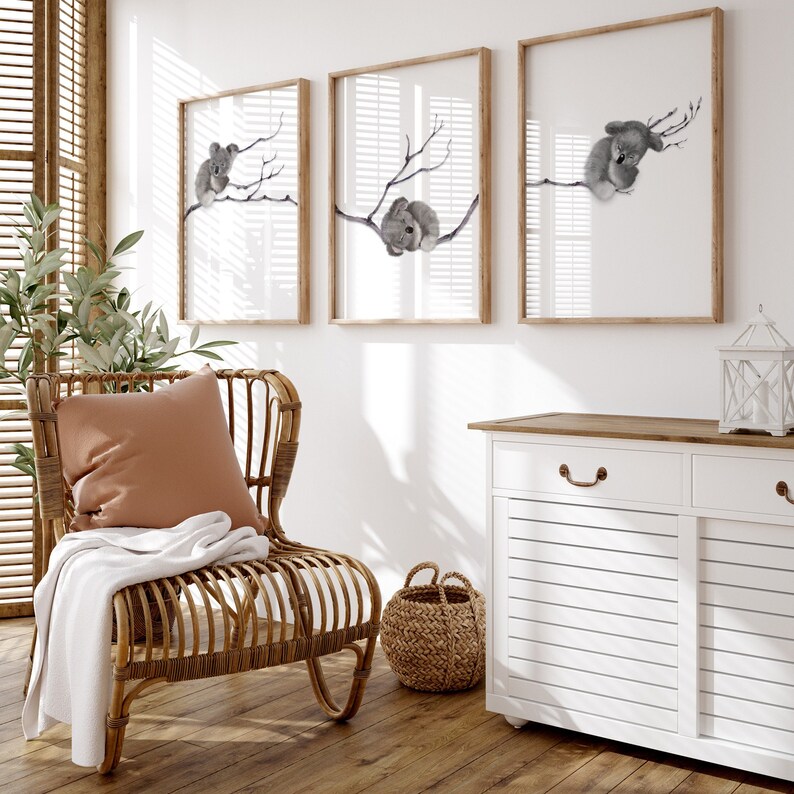 a set of three digital prints featuring a gum tree branched spanned across the three prints with a baby koala sleeping on the branch in each print. Perfect for any room but great for creating a peaceful, serene environment in a baby nursery.