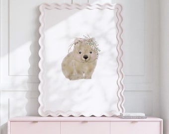 May include: A rectangular wall art print featuring a light brown, fluffy wombat illustration with a delicate floral crown on its head. The artwork is displayed within a light pink, wavy-edged frame, creating a soft and decorative visual display.