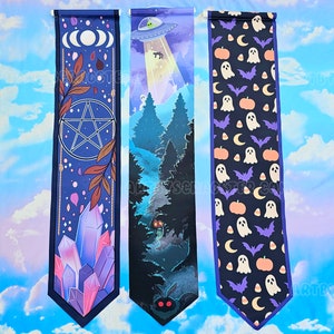 May include: Three decorative banners with unique designs. One features a pentagram, crystals, and celestial elements. Another depicts an alien abduction scene in a forest. The third showcases Halloween-themed ghosts, pumpkins, and bats.