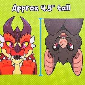 May include: Two cartoon stickers, one of a red and orange dragon and the other of a brown bat hanging upside down. The stickers are approximately 4.5 inches tall. The background is light green with white polka dots.