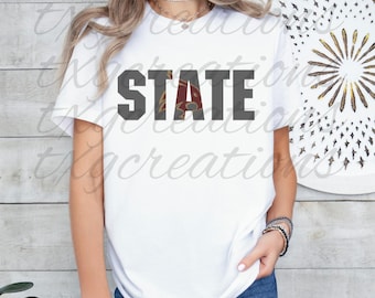 May include: A white t-shirt with the word "STATE" printed in dark gray across the front. The letter "A" in "STATE" is a maroon color. The shirt is paired with blue jeans. The overall theme is casual wear.