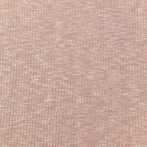 May include: A close-up of a soft, textured fabric in a light pink color. The fabric has a waffle-like texture and a subtle sheen.