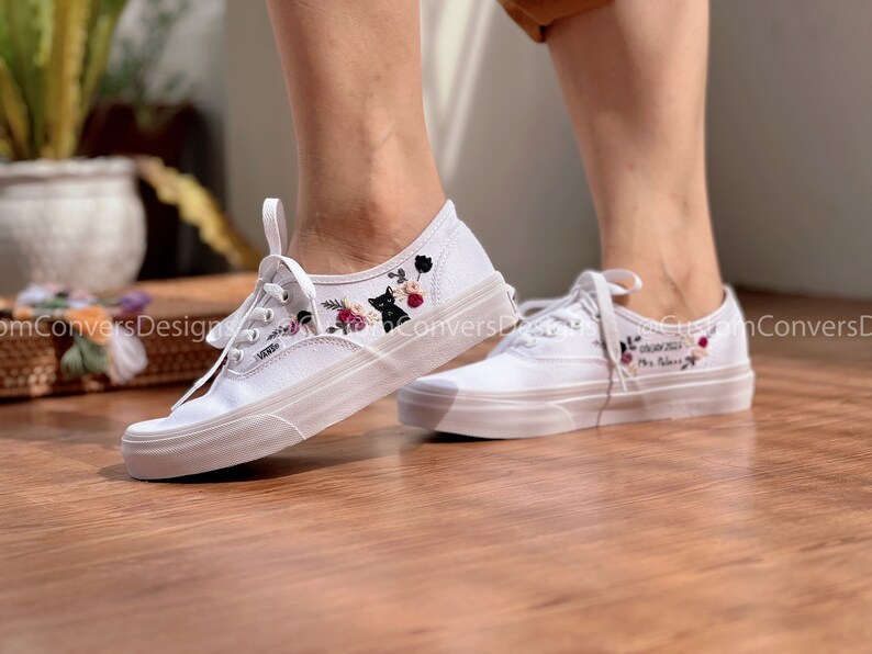 May include: White canvas shoes with black cat and floral embroidery. The left shoe has the text "My Beloved" embroidered on it.