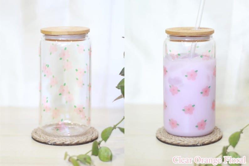 May include: A clear glass jar with a bamboo lid and a floral pattern. The jar is filled with a light purple liquid and has a straw in it. The jar is sitting on a rope coaster. The text "Clear Orange Floral" is visible at the bottom of the image.