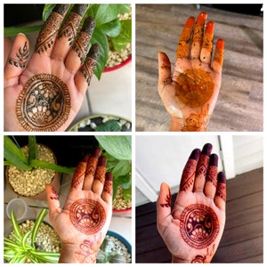May include: Close-up of hands adorned with intricate henna designs. The henna is a deep reddish-brown color, featuring circular patterns and floral motifs on the palms and detailed patterns on the fingers. The designs are applied to the skin.