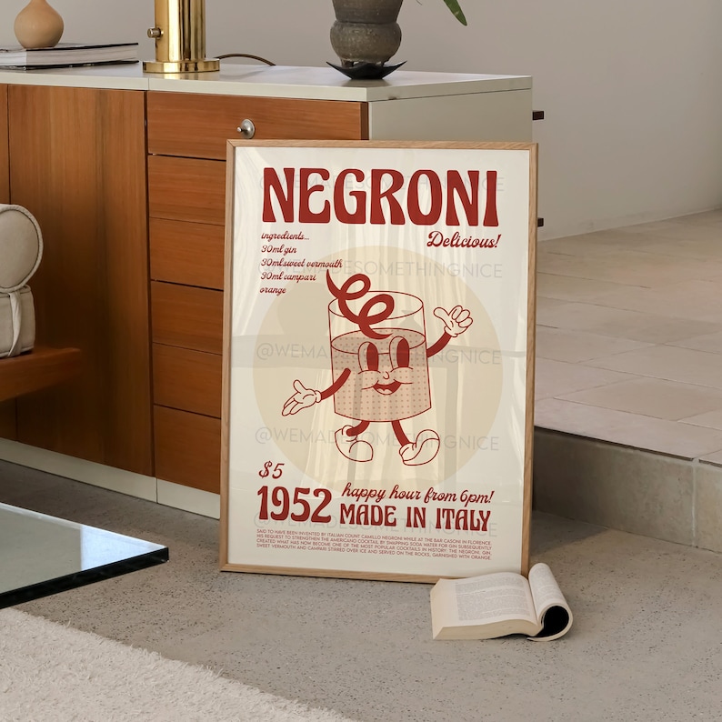 Peut inclure: Une affiche encadr&eacute;e rectangulaire repr&eacute;sentant un personnage en forme de verre avec des bras et des jambes. Le texte indique NEGRONI, Delicious!, 30ml gin, 30ml sweet vermouth, 30ml campari, orange, $5, 1952, happy hour from 6pm!, et MADE IN ITALY.