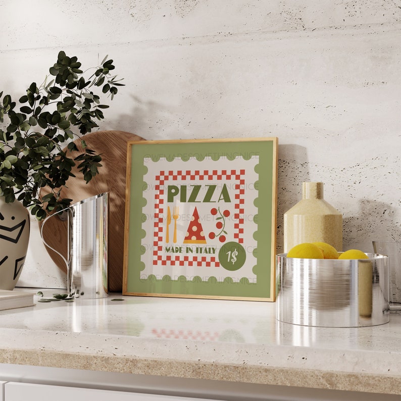 May include: A green framed print with a red and white chequered border. The print features a pizza slice with a fork and knife, and the text "PIZZA MADE IN ITALY 1$".
