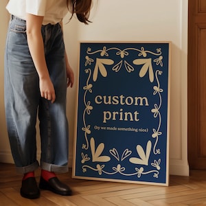 May include: A blue and gold sign with the text "custom print (by we made something nice)" surrounded by a decorative border of stylized flowers.