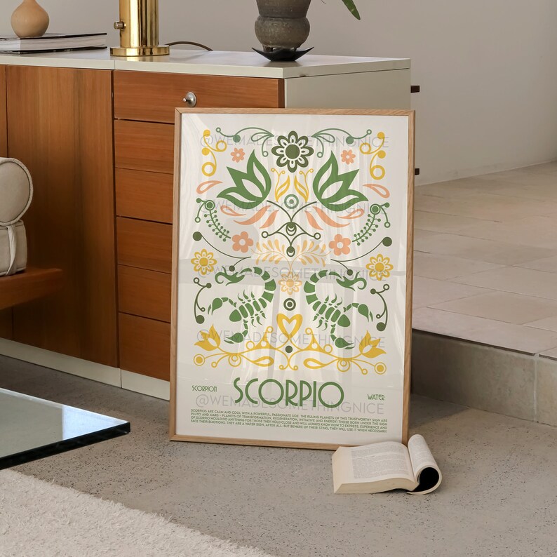 May include: A white poster with a green, yellow, and orange floral design featuring a scorpion. The poster has the text "Scorpio" in large, bold letters and the text "@WEARE.SOMETHING.NICE" in smaller letters.