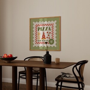 May include: A framed green and red poster with the words "Pizza Made in Italy 1$" and a cartoon pizza slice with a red and white checkered background.