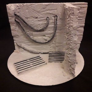 Könnte beinhalten: Ein weißes, strukturiertes Diorama-Set mit einer weißen Basis. Das Set enthält eine weiße Wand mit schwarzen Rohren und zwei weiße, lattenartige Plattformen.