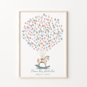 May include: A white wooden rocking horse with a red saddle and brown reins, surrounded by a cluster of pastel blue, pink, and brown fingerprint balloons. The text "Dream Big, Little One" and "August 17, 2019" is printed below the horse.