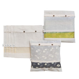 May include: Set of three white cotton storage bags with a clear window. The bags have a button closure and are perfect for storing and organizing items. The bags are shown with different patterned fabrics inside.