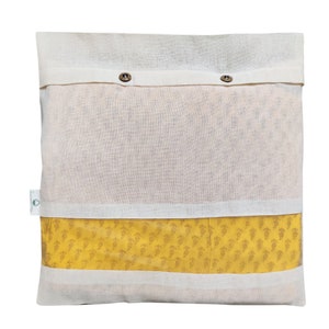 May include: A white cotton storage bag with two button closures. The bag has a clear window that shows a yellow fabric with a small, repeating pattern.