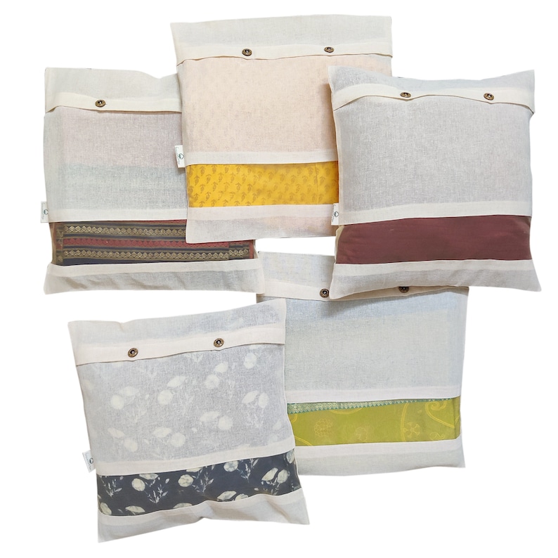 May include: Five white cotton pillow covers with different colored fabric inserts. The inserts are visible through the white fabric. The pillow covers have buttons on the front.