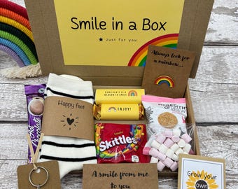 Cadeau Sourire dans une boîte : insigne arc-en-ciel, chaussettes, porte-clés fait main, bracelet fait main, graines de tournesol et friandises