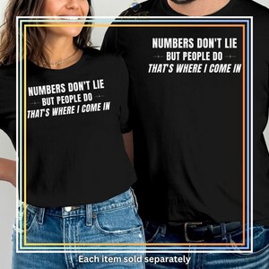 May include: Black t-shirts with the text "NUMBERS DON'T LIE BUT PEOPLE DO THAT'S WHERE I COME IN" in white. The shirts are worn by two people, with the text centered on the chest. The phrase "Each item sold separately" is at the bottom.