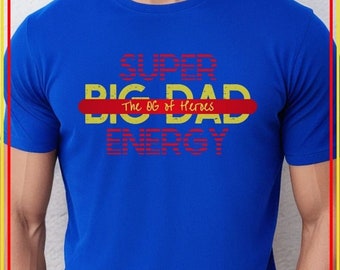 May include: Blue t-shirt with the text "SUPER BIG DAD The OG of Heroes ENERGY" in red and yellow lettering.