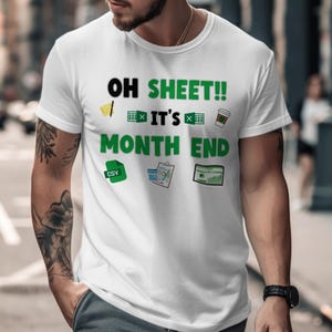 May include: White t-shirt with the text "OH SHEET!! IT'S MONTH END" in black and green. The shirt features small graphics of a spreadsheet, coffee cup, and a CSV file. The design is centered on the front of the shirt.