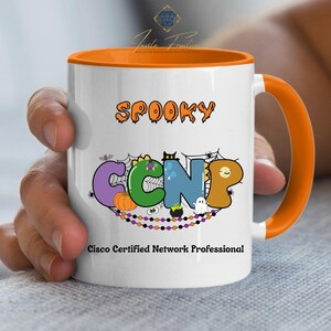 May include: White ceramic mug with an orange interior and handle. The mug displays the word "SPOOKY" above the letters "CCNP" in a Halloween design. The text "Cisco Certified Network Professional" is printed below.