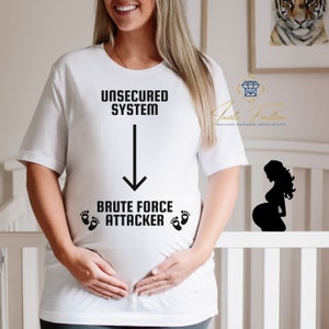Op de afbeelding: Een wit T-shirt met de tekst "UNSECURED SYSTEM" en een pijl die naar beneden wijst naar de tekst "BRUTE FORCE ATTACKER" met twee voetafdrukken aan weerszijden. Het shirt wordt gedragen door een zwangere persoon.
