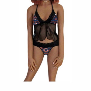 May include: Black lingerie set with a sheer top and a lace trim. The top has a Chicago Bears logo print. The bottom has a Chicago Bears logo print and a large "C" in the center.