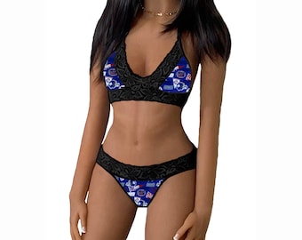 Könnte beinhalten: Schwarzes Spitzen-Dessous-Set mit einem blauen und weißen gemusterten Stoff mit dem Logo eines Sportteams. Der BH hat einen Halterneck-Stil und der Slip ist ein frecher Stil.